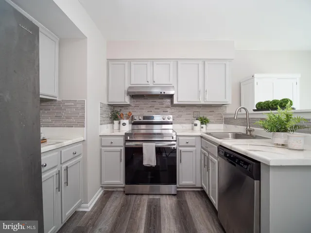 a kitchen with stainless steel appliances granite countertop a stove sink and cabinets