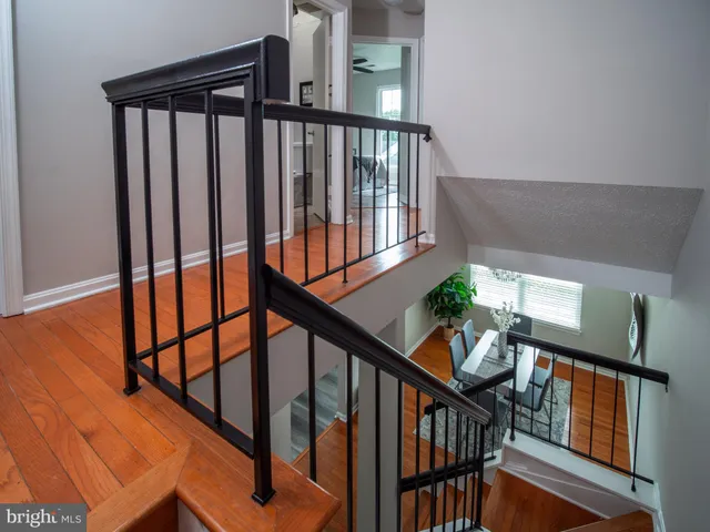 a view of staircase with wooden floor and white walls