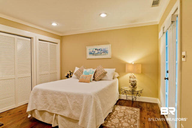 25773 Canal Road, Unit 26 Orange Beach, AL 36561 - Photo 2 of 42 This bedroom has pine floors and has a small covered porch to sit on through the french doors.