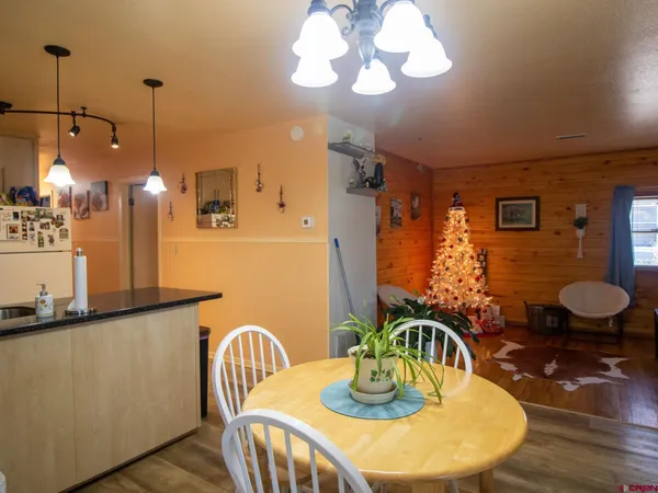a dining room filled chandelier and wooden floor