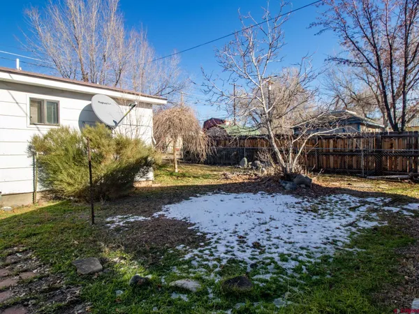 a view of a yard with wooden fence