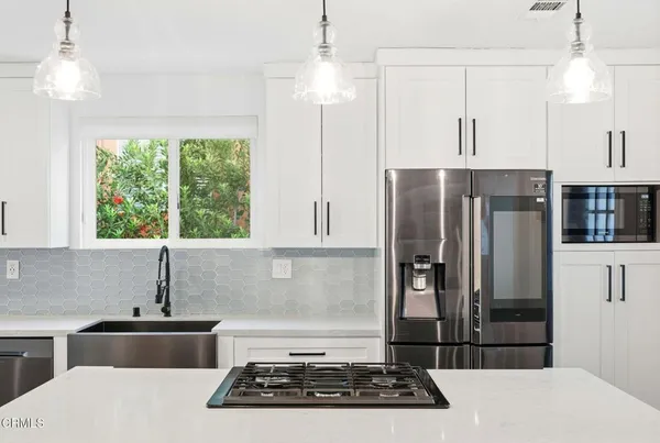 a kitchen with stainless steel appliances a stove a refrigerator and a sink