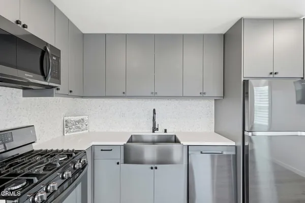 a kitchen with stainless steel appliances a sink a stove and a refrigerator