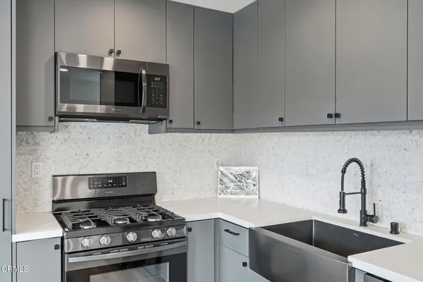 a kitchen with stainless steel appliances a stove a microwave and sink