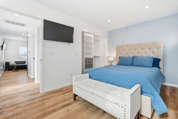 a bedroom with a bed and a flat screen tv