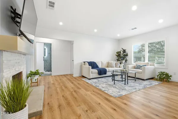 a living room with furniture a potted plant and a fireplace