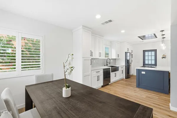 a kitchen with stainless steel appliances granite countertop a sink cabinets and wooden floor