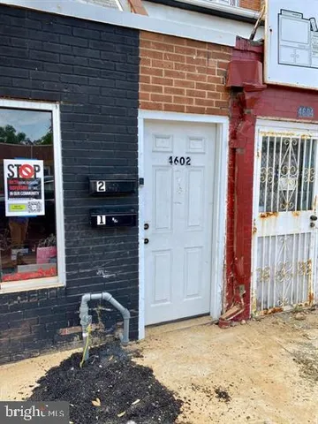 a brick building with a bench next to a road