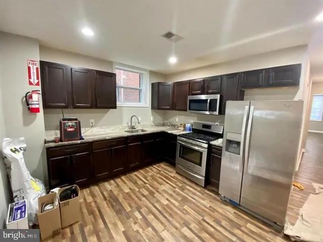 a kitchen with a refrigerator sink and wooden cabinets