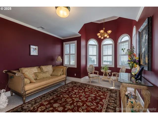 a living room with furniture chandelier and a large window