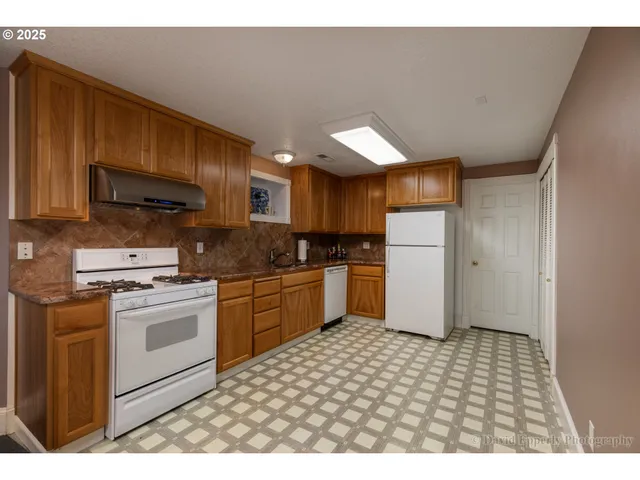 a kitchen with a sink a refrigerator and cabinets