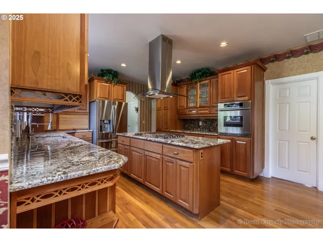a kitchen with stainless steel appliances granite countertop a stove a sink and a refrigerator