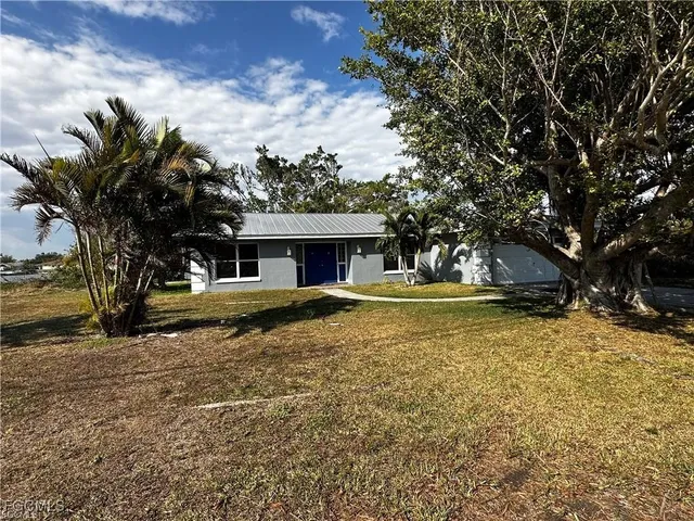 a front view of house with yard and trees around