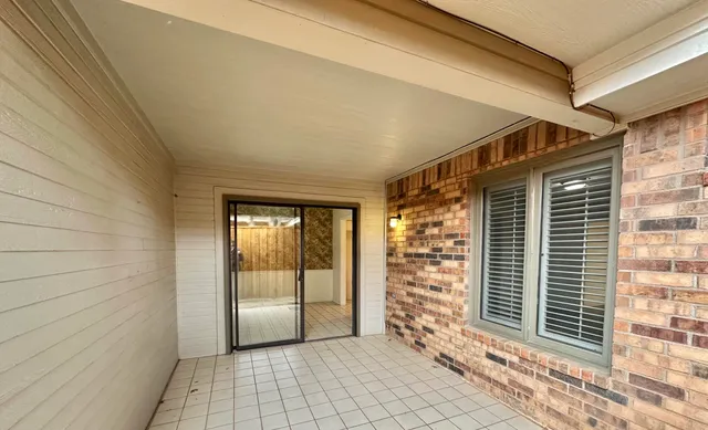 a view of a porch with a table and chairs