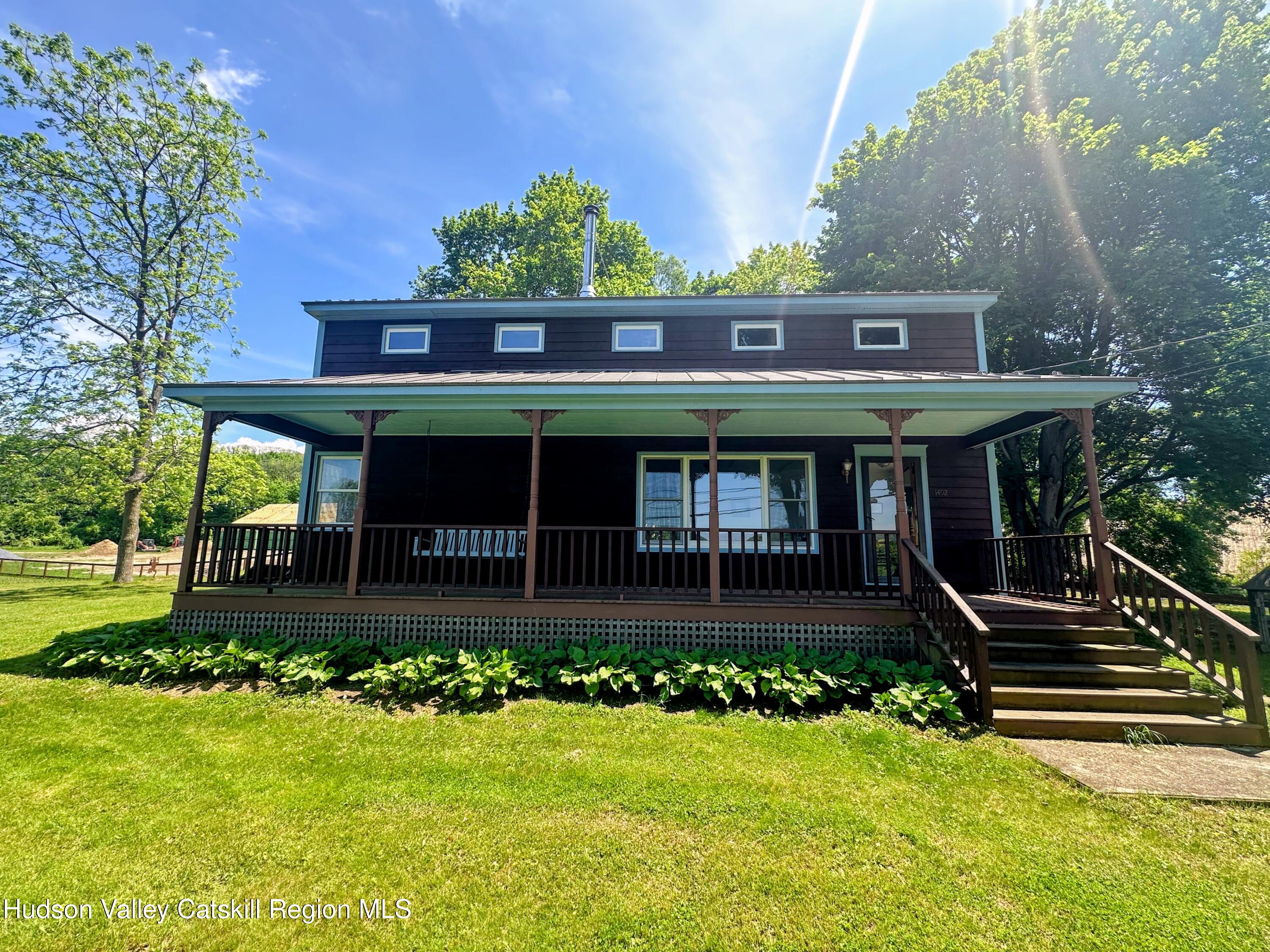 1492 County Road Copake, NY 12516 - Photo 22 of 34 a front view of a house with a yard table and chairs