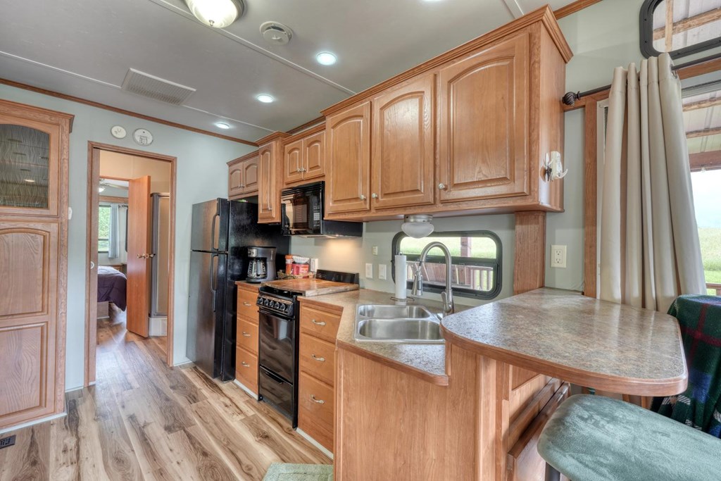 568 Parks Road Hiawassee, GA 30546 - Photo 14 of 38 a kitchen with stainless steel appliances granite countertop a refrigerator a stove top oven a sink dishwasher and wooden cabinets with wooden floor