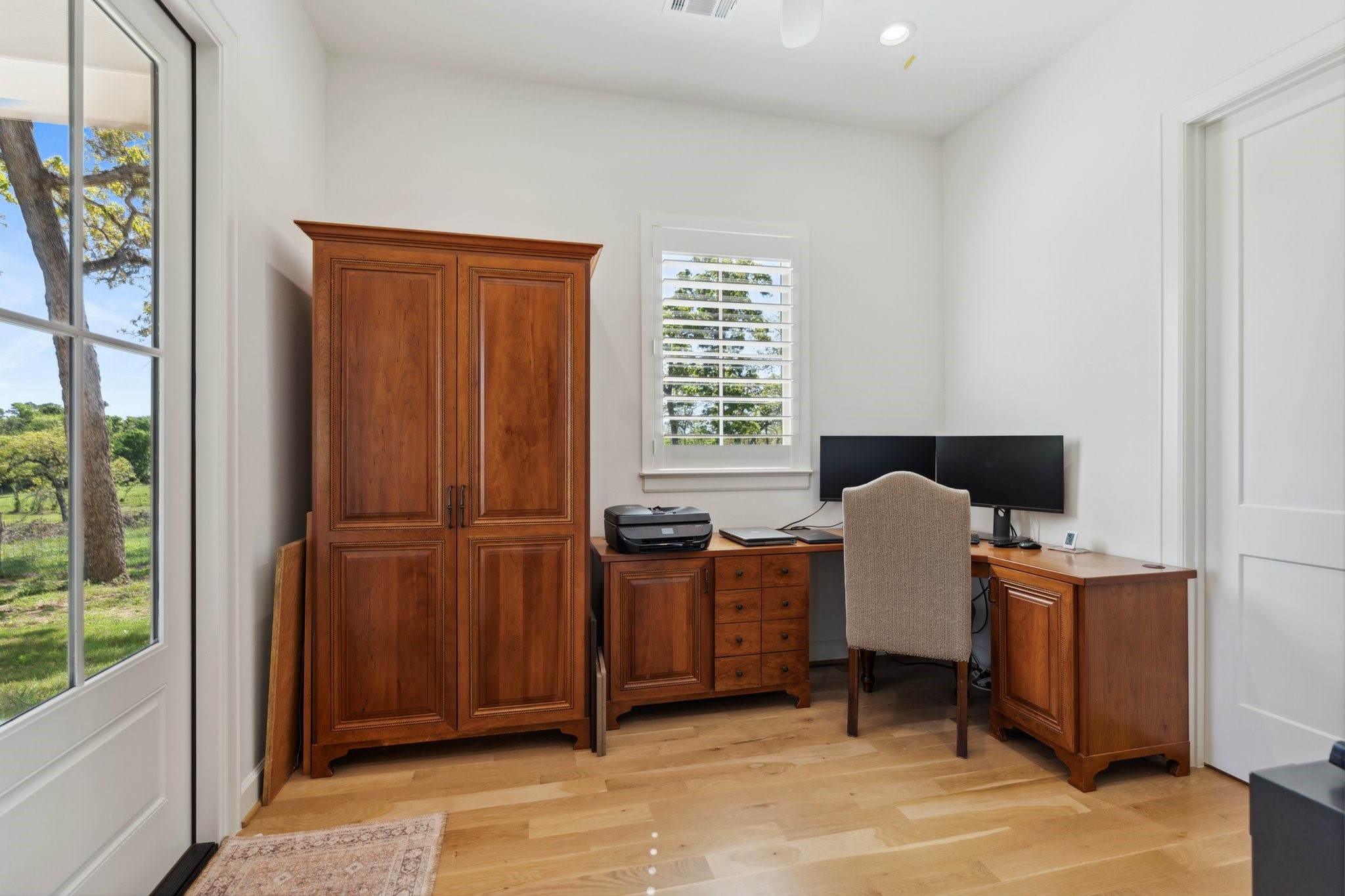 4052 Kuykendall Road Bellville, TX 77418 - Photo 17 of 40 The office or sitting room, seamlessly connected to the primary bedroom and closet, offers tranquil backyard views and direct outdoor access, perfect for work or relaxation.