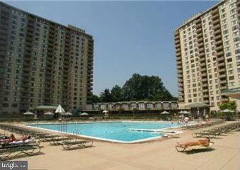 a view of swimming pool with outdoor seating and lake view