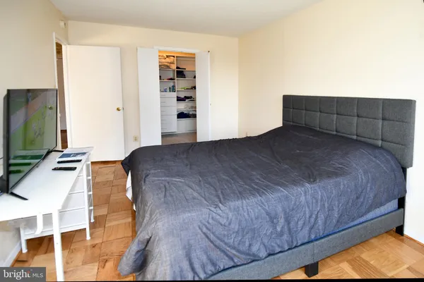 a spacious bedroom with a bed and a flat screen tv