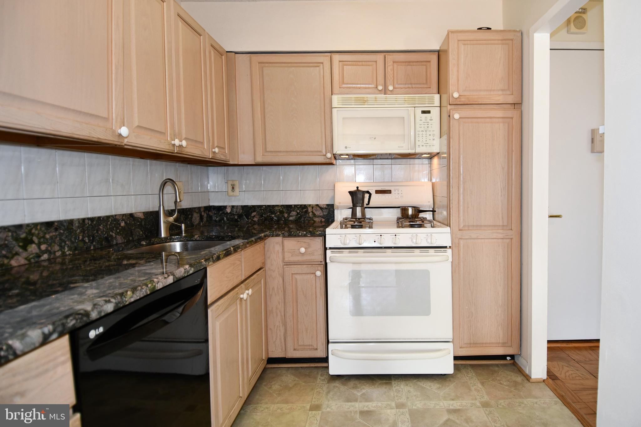 5225 Pooks Hill Road, Unit 803N Bethesda, MD 20814 - Photo 3 of 43 a kitchen with granite countertop white cabinets and white appliances