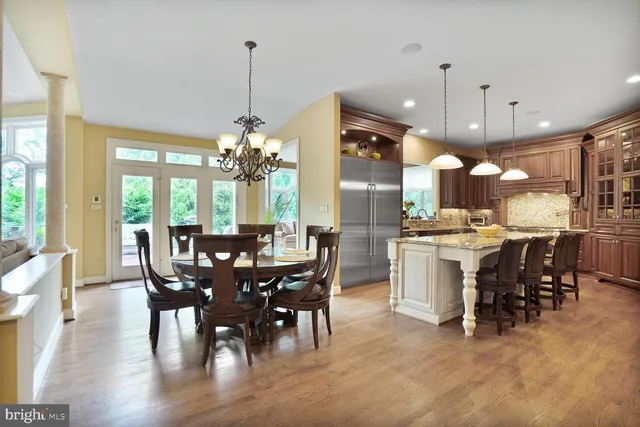 a kitchen with stainless steel appliances granite countertop a table chairs and a chandelier