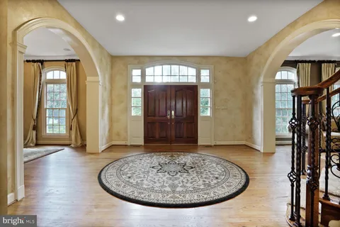 a dining room with chandelier and wooden floor