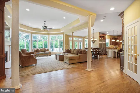 a living room with furniture large windows and a fireplace