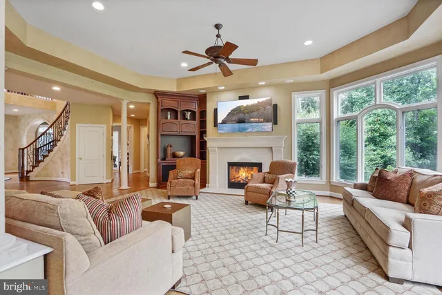 a living room with furniture a ceiling fan and a fireplace