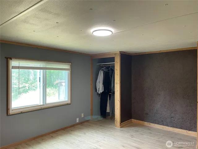 an empty room with closet and windows