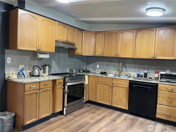 a kitchen with granite countertop wooden cabinets a sink and a stove