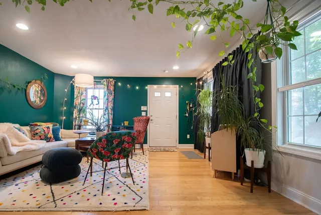 a living room with furniture a potted plant and a large window