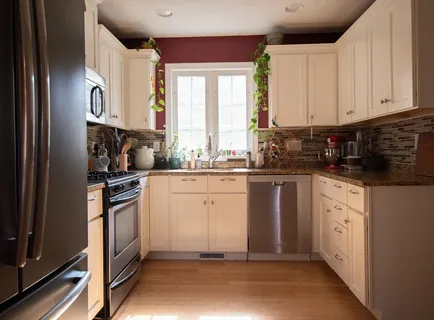 a kitchen with granite countertop white cabinets and white appliances