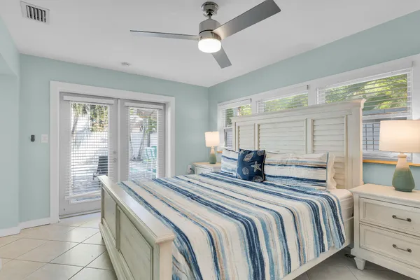 a bedroom with a large bed and a chandelier fan