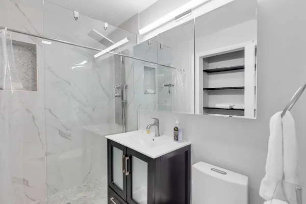 a bathroom with a sink a toilet and a mirror