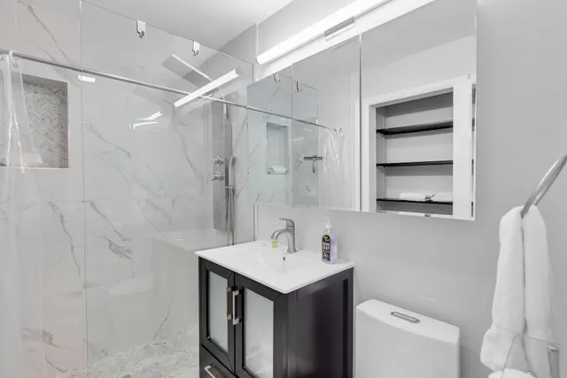 a bathroom with a sink a toilet and a mirror