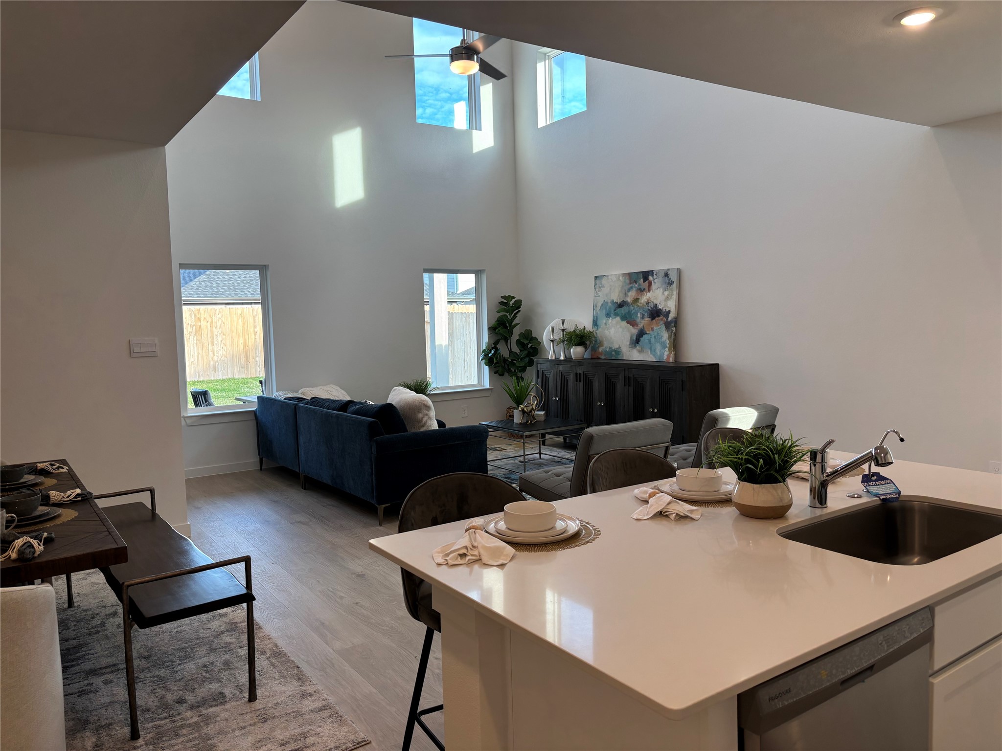 4315 Windsor Forest Fulshear, TX 77494 - Photo 11 of 50 Bright and spacious open-concept living area with high ceilings, large windows, and modern finishes. The kitchen features a sleek island, and the living room is inviting with stylish decor. Perfect for entertaining and family gatherings.