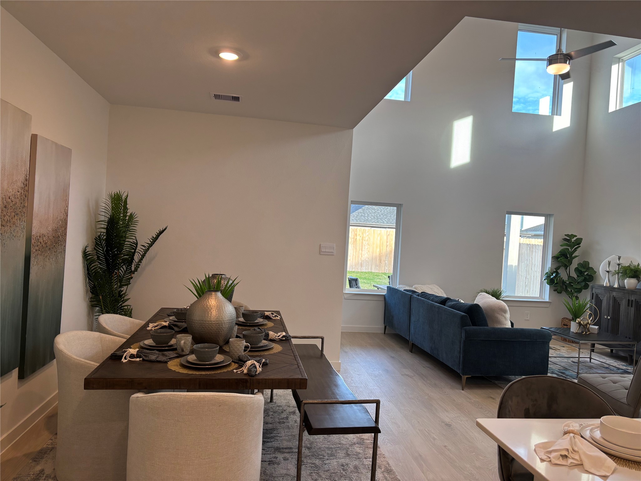 4315 Windsor Forest Fulshear, TX 77494 - Photo 12 of 50 This open-concept living space features high ceilings, abundant natural light, and a modern dining area. The adjacent living room offers a cozy seating arrangement, complemented by stylish decor and large windows overlooking the backyard.