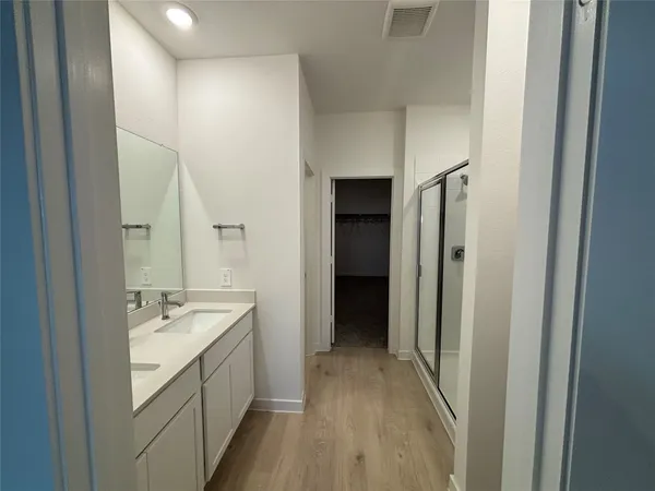 a kitchen with a sink and wooden floor