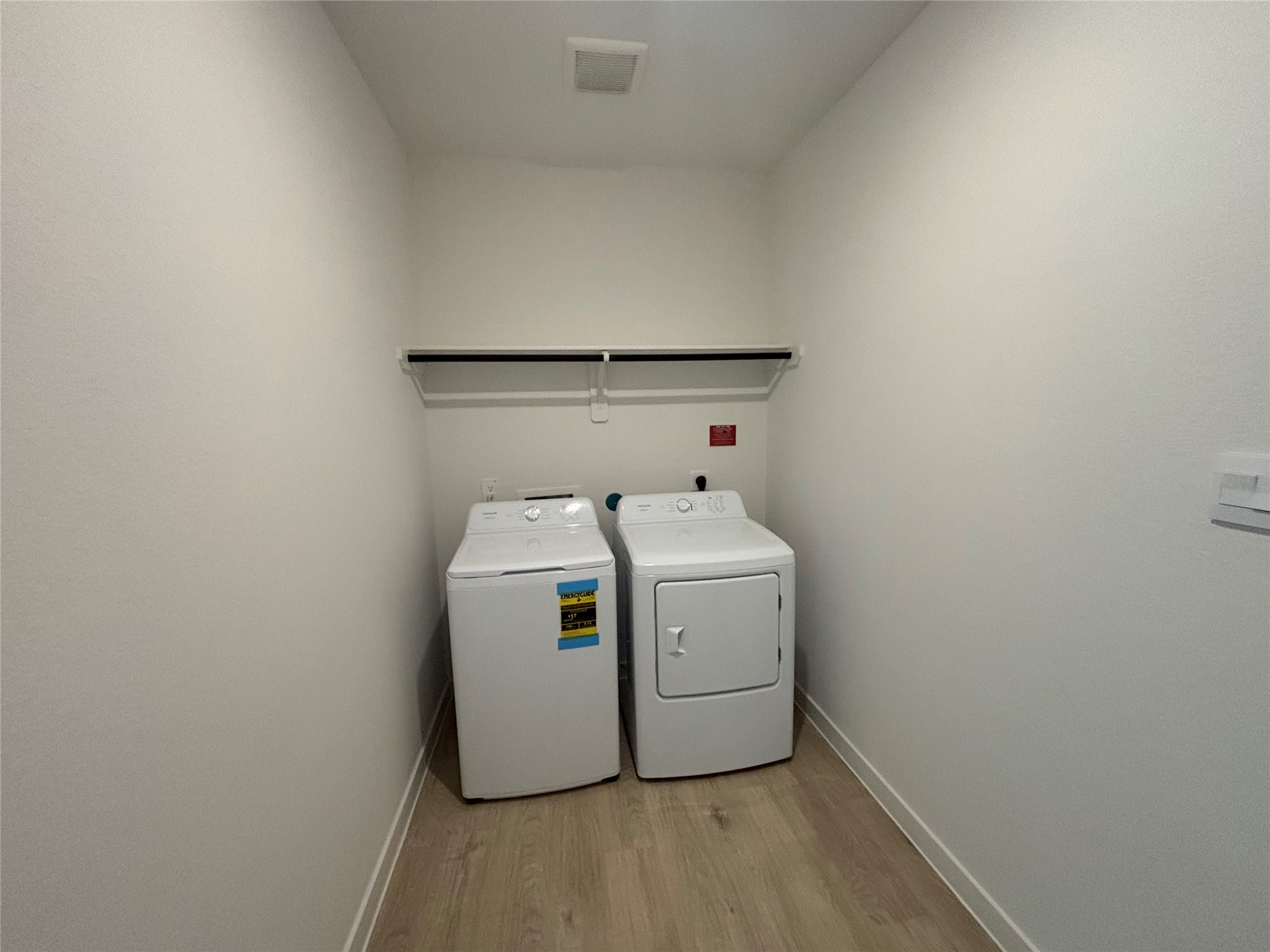 4315 Windsor Forest Fulshear, TX 77494 - Photo 23 of 50 This is a well-lit laundry room with light wood flooring, featuring new Frigidaire washer and dryer.