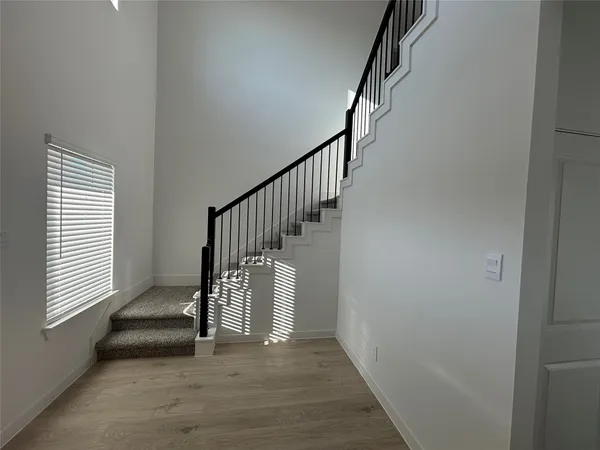 a view of entryway and hall with wooden floor