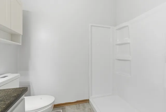 a white toilet sitting next to a bath tub