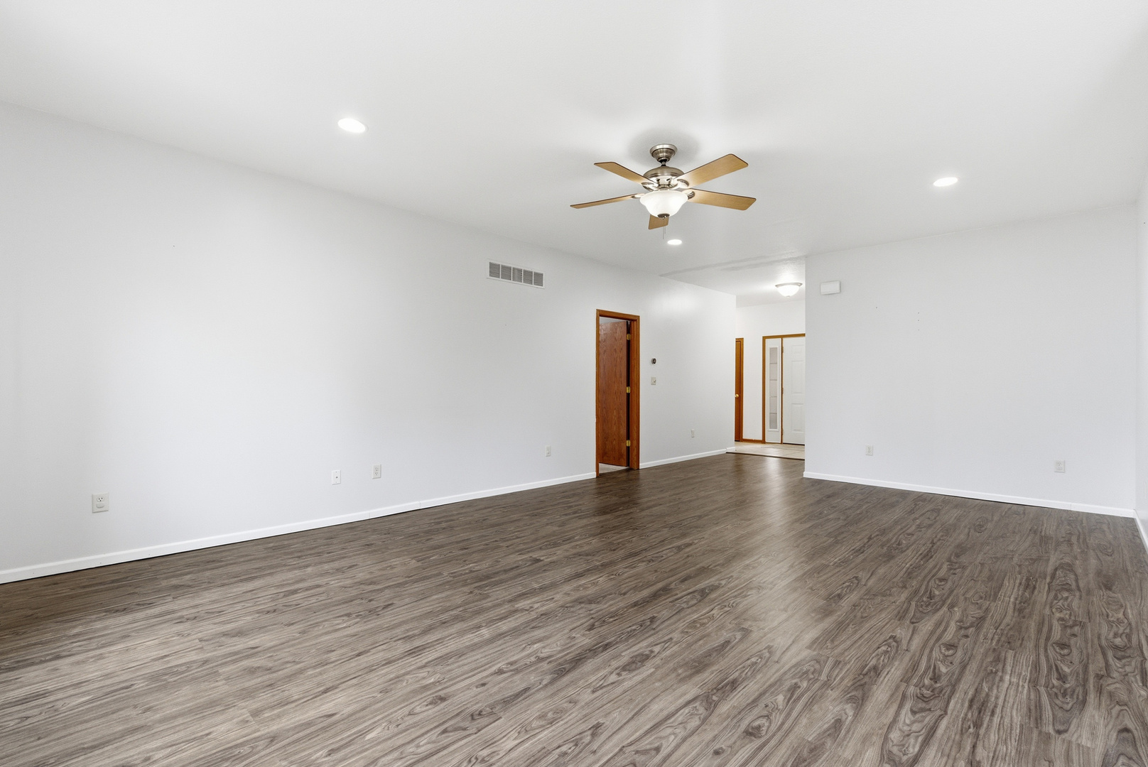 660 West 1st Street Braidwood, IL 60408 - Photo 4 of 19 an empty room with wooden floor and a ceiling fan