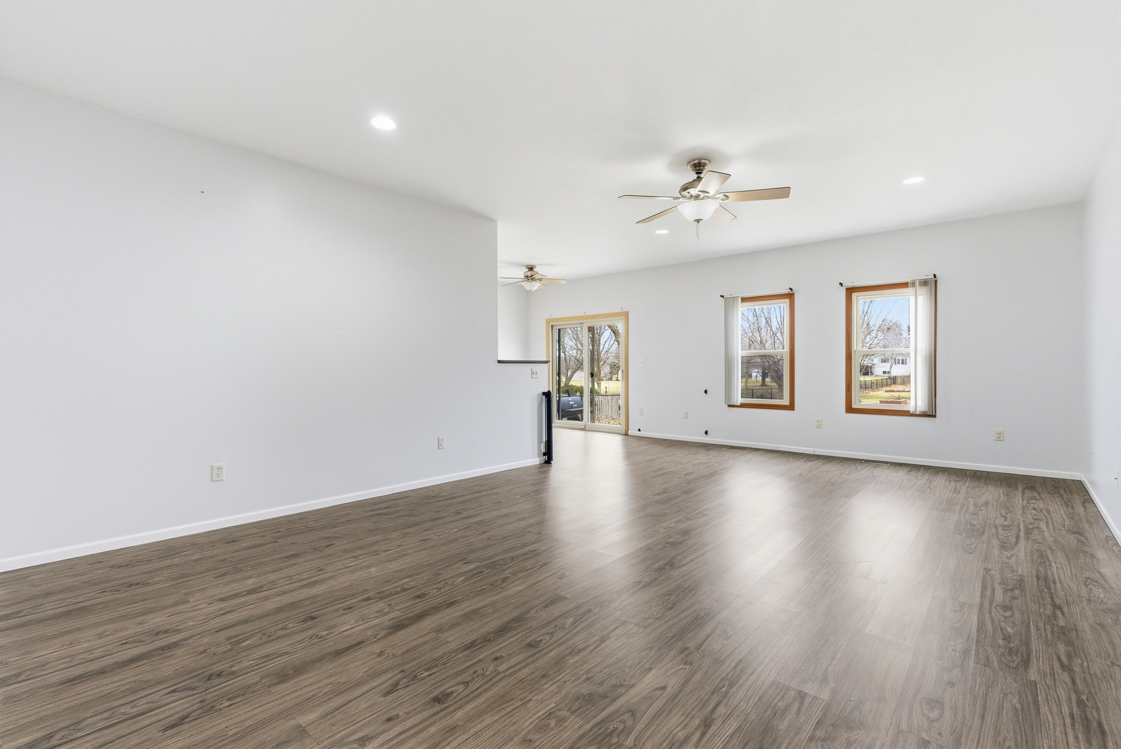 660 West 1st Street Braidwood, IL 60408 - Photo 5 of 19 an empty room with wooden floor ceiling fan and windows