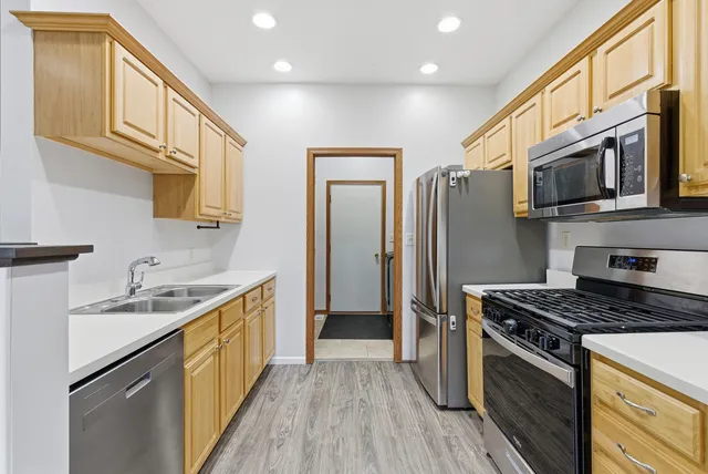 a kitchen with stainless steel appliances granite countertop a stove a sink and a refrigerator