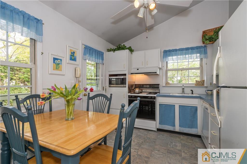 6 Paley Place Edison, NJ 08817 - Photo 8 of 18 a kitchen with stainless steel appliances granite countertop a stove a sink dishwasher a dining table and chairs with wooden floor