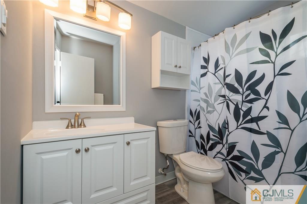 6 Paley Place Edison, NJ 08817 - Photo 10 of 18 a bathroom with a toilet sink and mirror