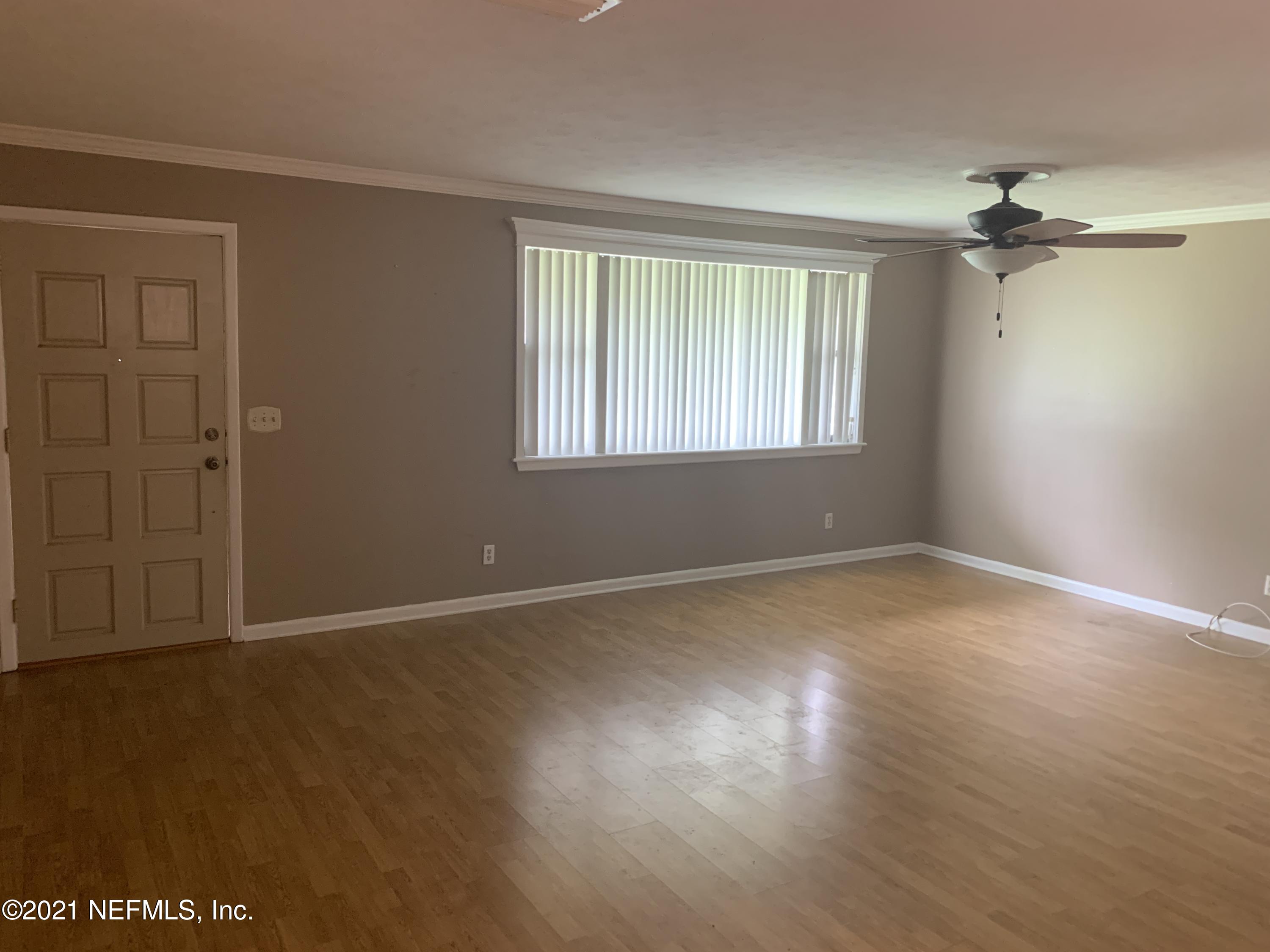 4126 Dayrl Road Jacksonville, FL 32207 - Photo 3 of 26 a view of an empty room with wooden floor and a window