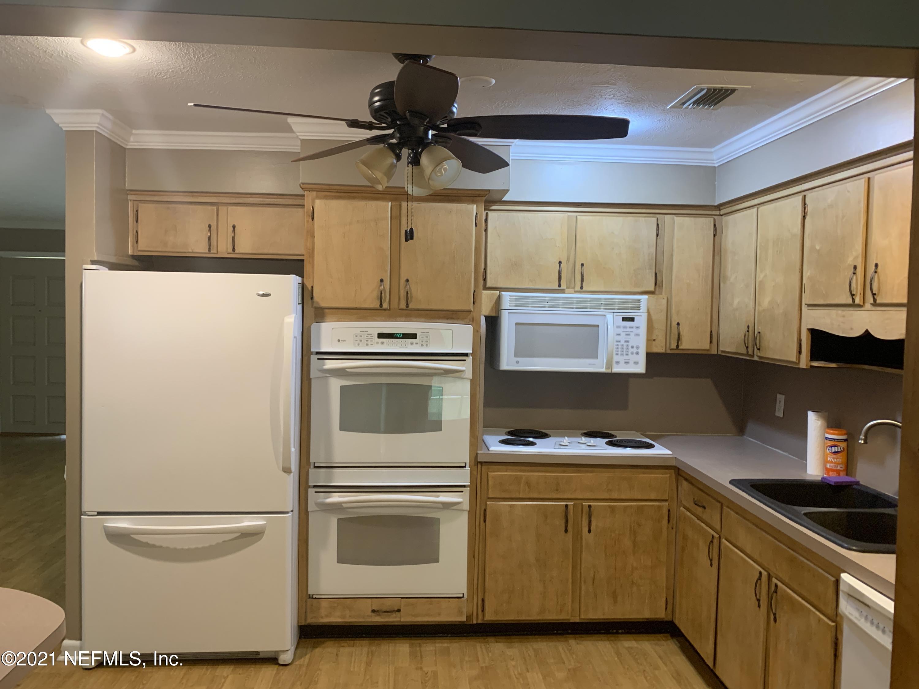 4126 Dayrl Road Jacksonville, FL 32207 - Photo 7 of 26 a kitchen with a refrigerator and a stove top oven
