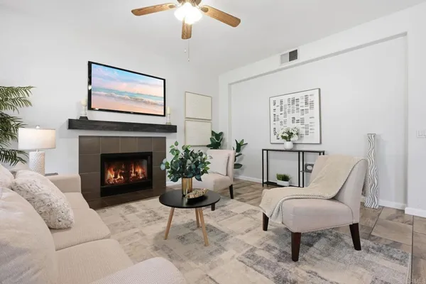 a living room with furniture a fireplace and a chandelier