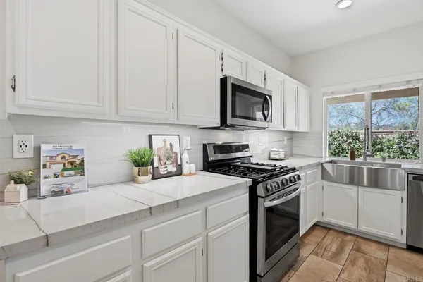 a kitchen with granite countertop sink cabinets and stainless steel appliances